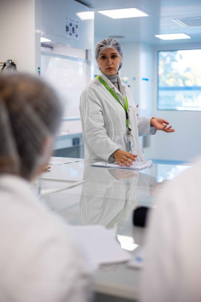 Chercheuse en laboratoire donnant un cours de TP à des étudiants