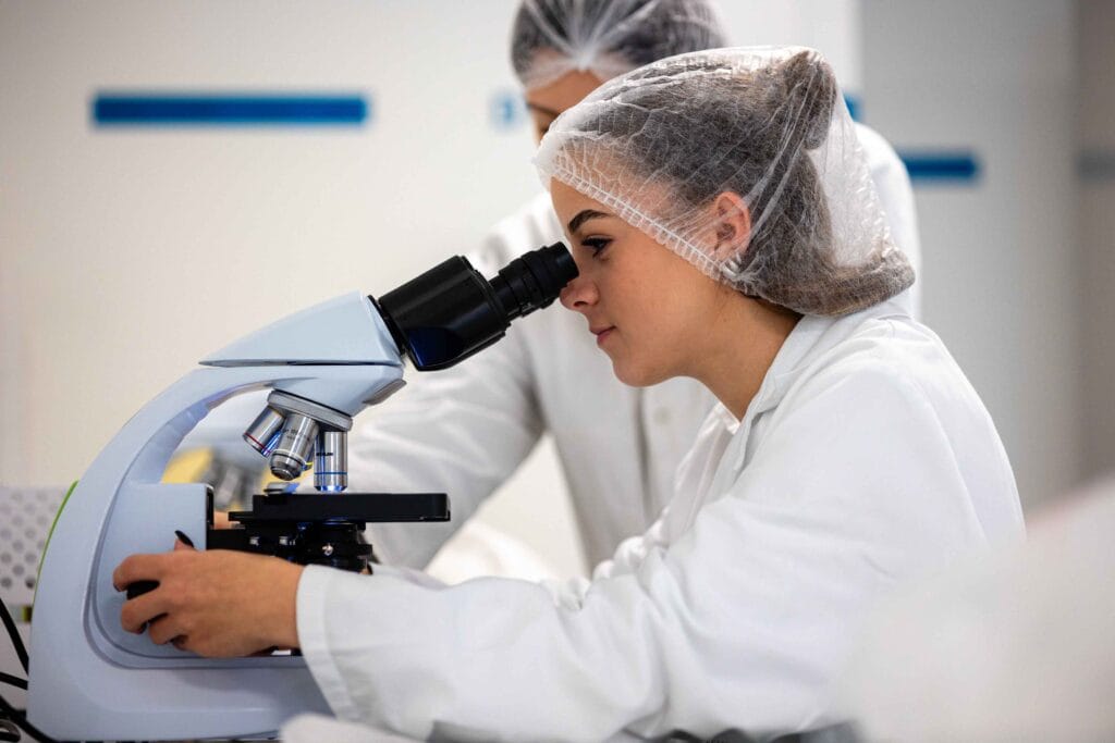 Étudiante utilisant un microscope lors d'un TP