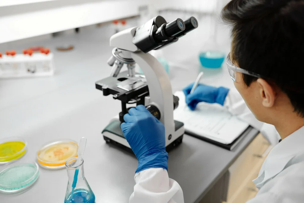 Technicien de laboratoire utilisant un microscope pour analyser des échantillons